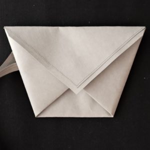 szara kopertówka w kształcie koperty - trapezu wykonana z washpapy - specjalnego materiały jak papier, który można prać i prasować