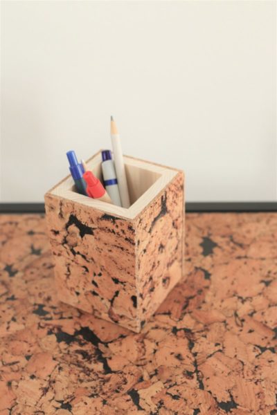 prostokątne drewniane pudełko na długopisy pokryte naturalnym korkiem. Korek w odcieniach brązowo-czarnych o satynowym woskowym wykończeniu, bardzo miłym w dotyku.